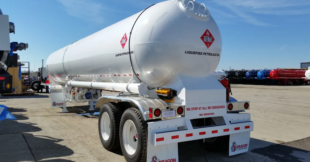 Liquefied petroleum gas tanker with safety labels in a storage facility.